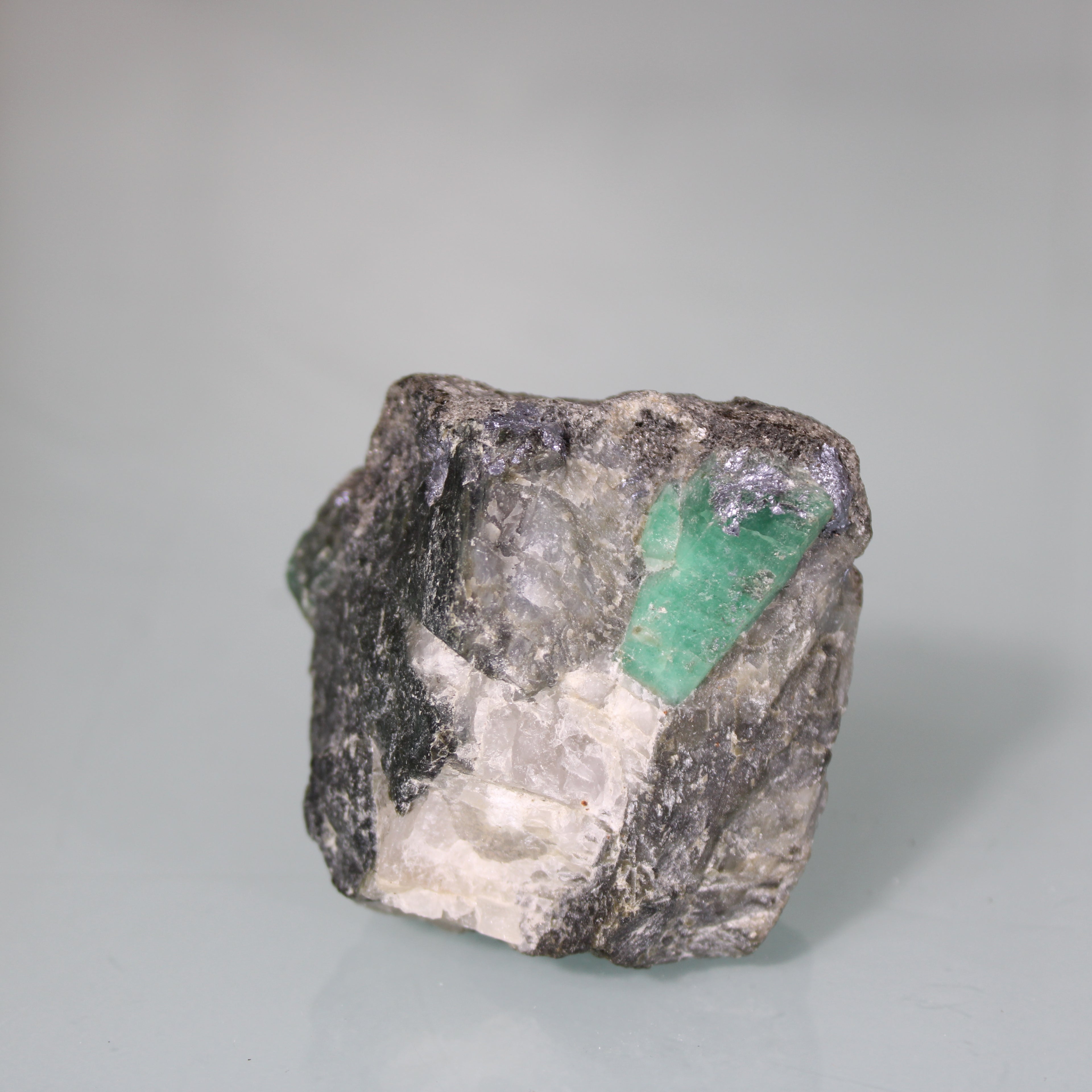 Esmeralda na Matriz  – Brilho Verde em Rocha Bruta Escura
